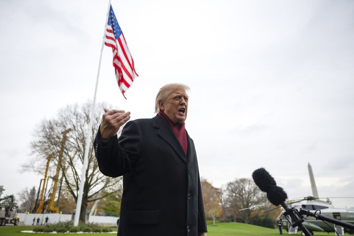 Donald Trump speaking outdoors near American flag, referencing his New York skyscraper battle and crass piggy insult. Donald Trump speaking outdoors near American flag, referencing his New York skyscraper battle and crass piggy insult.