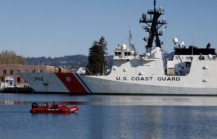 U.S. Coast Guard ship docked with a small boat nearby, highlighting Trump claims on redesigned ship aesthetics. U.S. Coast Guard ship docked with a small boat nearby, highlighting Trump claims on redesigned ship aesthetics.