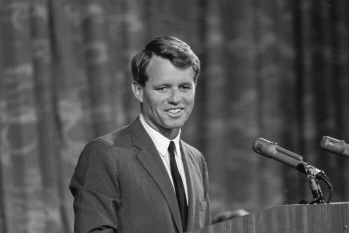 Robert F. Kennedy speaking at a podium with microphones, related to Kennedy and MLK assassination files.