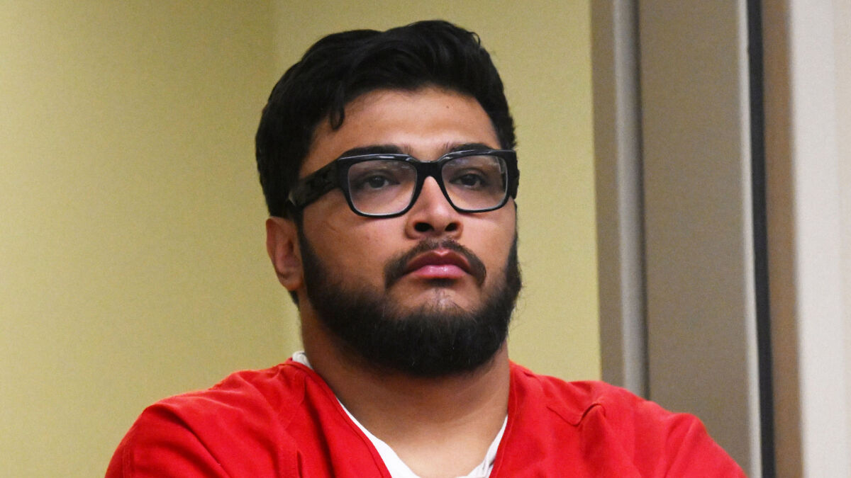 Man with glasses and beard wearing a red shirt appearing serious, related to Jake Haro torturing and k*****g baby Emmanuel case.
