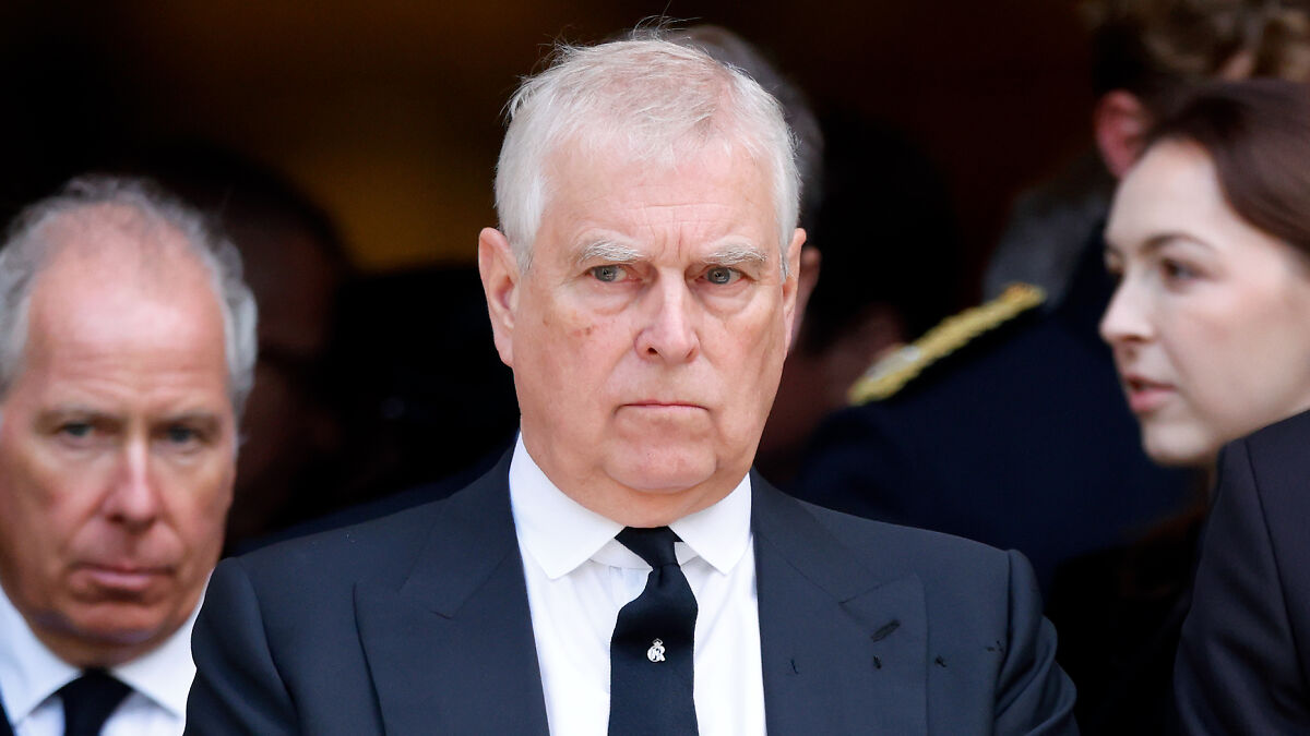 Former Prince Andrew wearing a black suit and tie, appearing serious amid U.S. Congress summons over Epstein links.