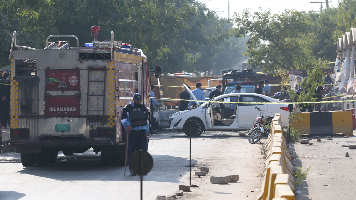 Police and emergency responders at scene of fatal car explosion in Pakistan following Delhi incident investigation.
