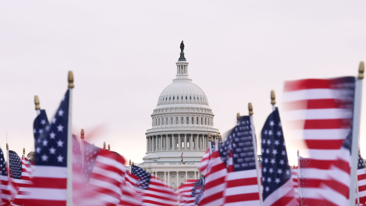 US Capitol dome with rows of American flags in foreground symbolizing battle for House seats ahead of 2026 midterms.