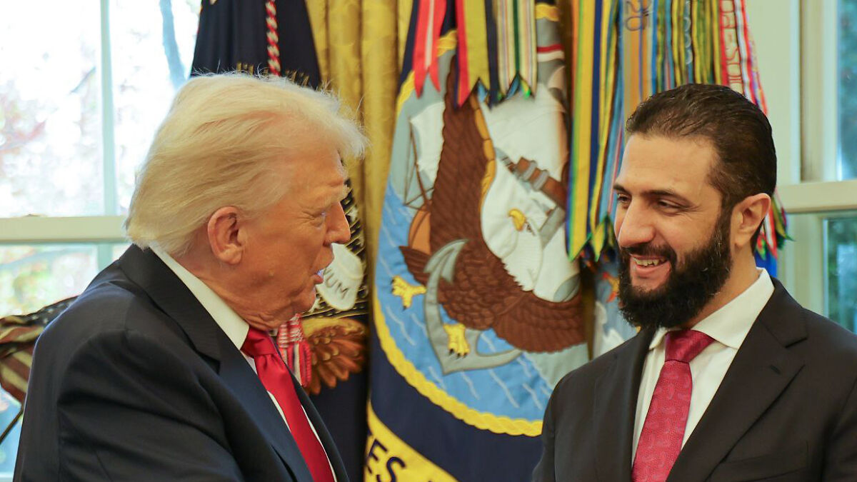 Donald Trump speaking to Syrian president at White House meeting, both wearing suits and red ties.