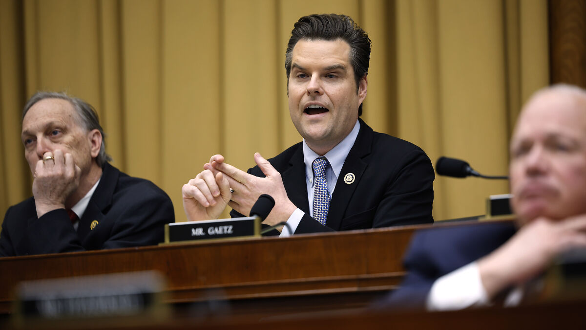 Man identified as Mr. Gaetz speaking during a formal government hearing with others seated nearby.