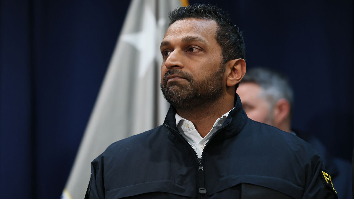 Man in an FBI jacket looking to the side during a press conference amid Epstein files investigation updates.