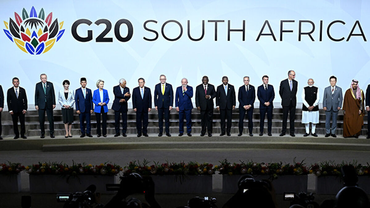 G20 world leaders standing on stage at South Africa summit discussing new energy and global cooperation.