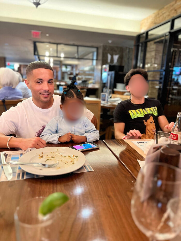 Navy sailor with son and another child sitting at a restaurant table after sharing a heartfelt moment. Navy sailor with son and another child sitting at a restaurant table after sharing a heartfelt moment.