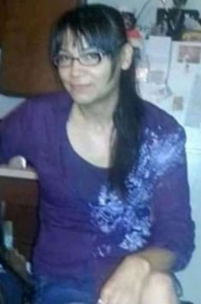 Indigenous woman with glasses and dark hair sitting indoors, related to remains found after missing case and a***e settlement.