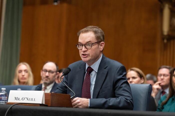Man identified as Mr. O'Neill speaks at a hearing, discussing Minnesota child care funds and fraud concerns. Man identified as Mr. O'Neill speaks at a hearing, discussing Minnesota child care funds and fraud concerns.