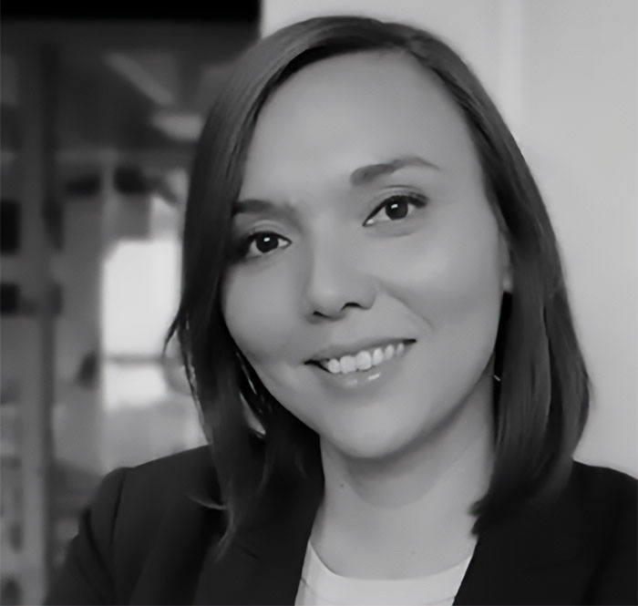 Smiling woman in a professional setting, illustrating conversation about coca leaf impact and d**g classification issues.