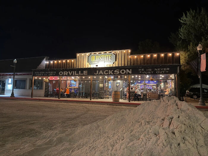 Bar exterior at night with patrons inside, illustrating a bar now offering free beer to anyone reporting migrants to ICE.
