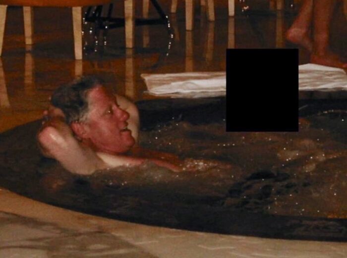 Bill Clinton relaxing in a hot tub, part of a controversial Epstein photo dump with censored content nearby.