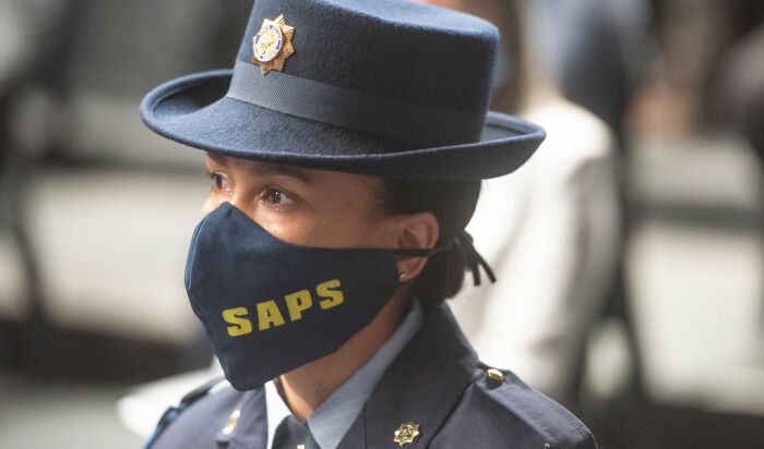 South African police officer wearing SAPS face mask and uniform at a briefing on fatal mass shooting victims including children and teens. South African police officer wearing SAPS face mask and uniform at a briefing on fatal mass shooting victims including children and teens.
