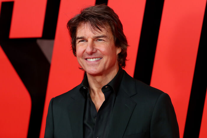 Tom Cruise smiling at a red carpet event, dressed in a black suit, linked to his epic space movie decision. Tom Cruise smiling at a red carpet event, dressed in a black suit, linked to his epic space movie decision.