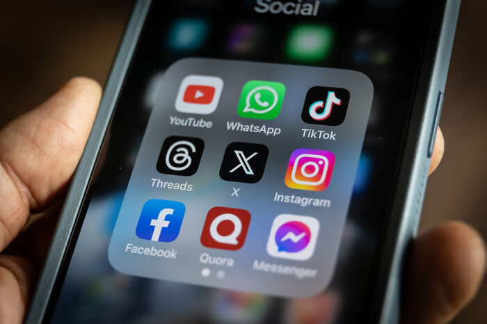 Smartphone screen showing social media apps including YouTube, WhatsApp, TikTok, X, and Instagram on a dark background. Smartphone screen showing social media apps including YouTube, WhatsApp, TikTok, X, and Instagram on a dark background.