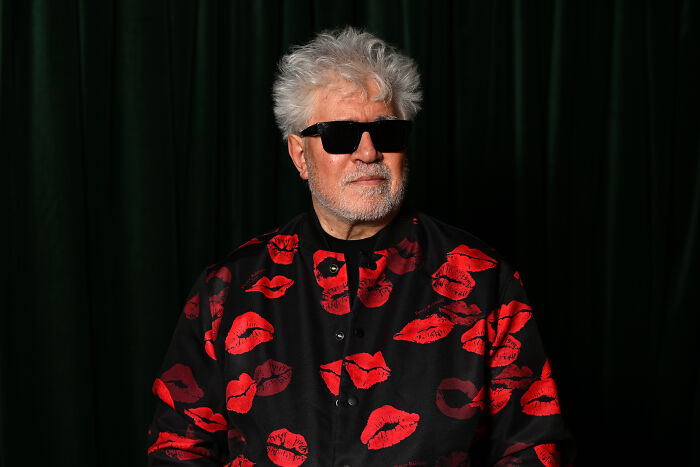 Man with white hair and black sunglasses wearing a black shirt with red lips pattern, related to celebrities slamming Donald Trump in 2025. Man with white hair and black sunglasses wearing a black shirt with red lips pattern, related to celebrities slamming Donald Trump in 2025.