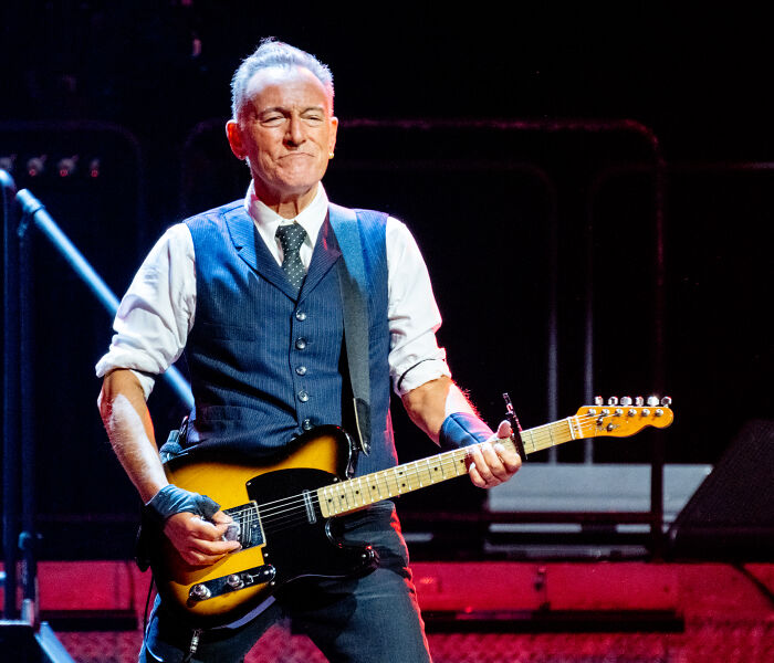 Male musician playing electric guitar on stage, representing celebrities who slammed Donald Trump in 2025. Male musician playing electric guitar on stage, representing celebrities who slammed Donald Trump in 2025.