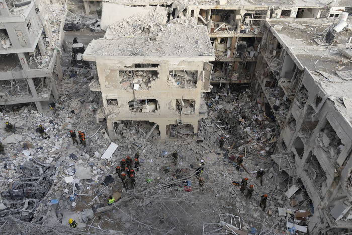 Rescue workers search through rubble of collapsed buildings after a devastating event linked to terrifying events near WW3 in 2025.