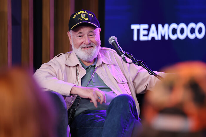 Rob Reiner wearing a cap and jacket, speaking into a microphone during a live event discussing Charlie Kirk assassination. Rob Reiner wearing a cap and jacket, speaking into a microphone during a live event discussing Charlie Kirk assassination.