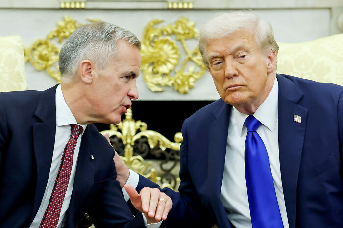 Donald Trump in a dark suit and blue tie speaking seriously with a world leader during a formal meeting on diplomacy. Donald Trump in a dark suit and blue tie speaking seriously with a world leader during a formal meeting on diplomacy.
