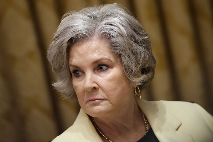 Woman with short gray hair and gold hoop earrings looking sideways, related to Trump’s chief of staff and alcoholic personality claims. Woman with short gray hair and gold hoop earrings looking sideways, related to Trump’s chief of staff and alcoholic personality claims.