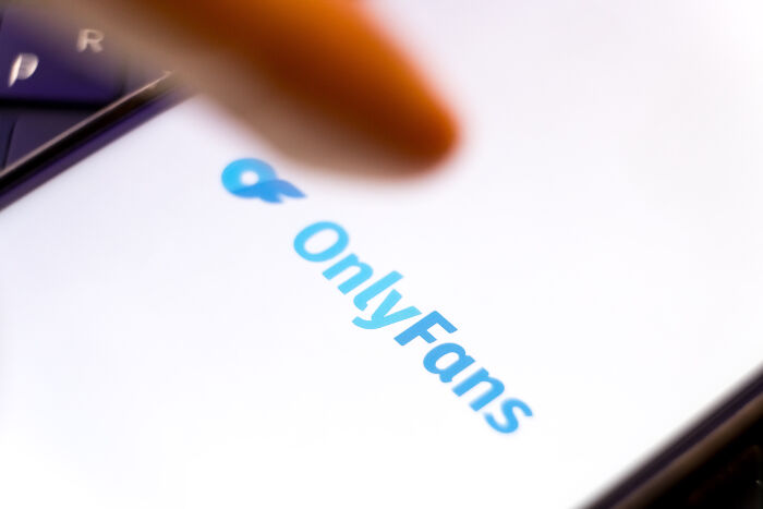 Close-up of a finger pointing to OnlyFans logo on a smartphone screen related to IRS agents reviewing x-rated content claims. Close-up of a finger pointing to OnlyFans logo on a smartphone screen related to IRS agents reviewing x-rated content claims.