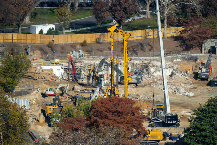 Construction site with heavy machinery and excavators amid autumn trees, unrelated to Trump’s cabinet meeting wild moments.