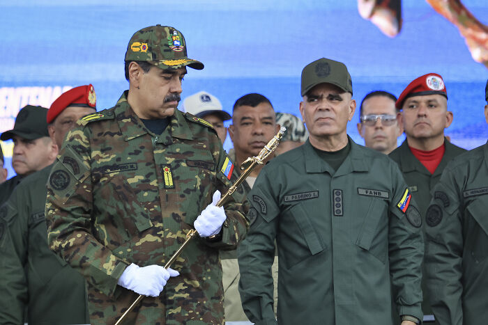 Military leaders in the Caribbean wearing uniforms during a formal event amid discussions on war crimes allegations. Military leaders in the Caribbean wearing uniforms during a formal event amid discussions on war crimes allegations.