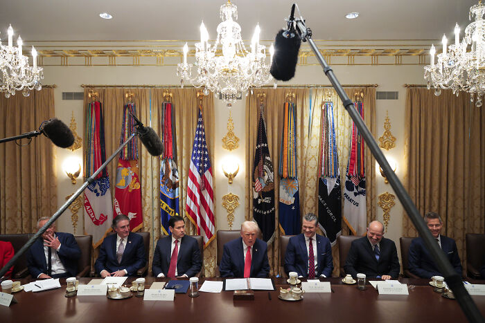 Donald Trump and Cabinet members seated at a long table during a tense and wild Cabinet meeting.