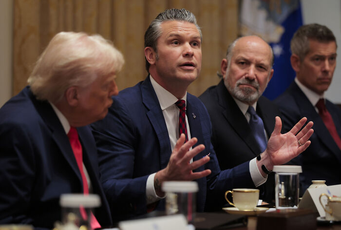 Trump’s cabinet meeting with officials in suits, intense discussion capturing one man gesturing during a heated moment.