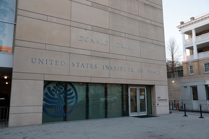 Entrance of the United States Institute of Peace building with Donald J. Trump name visible, related to renaming Kennedy Center.