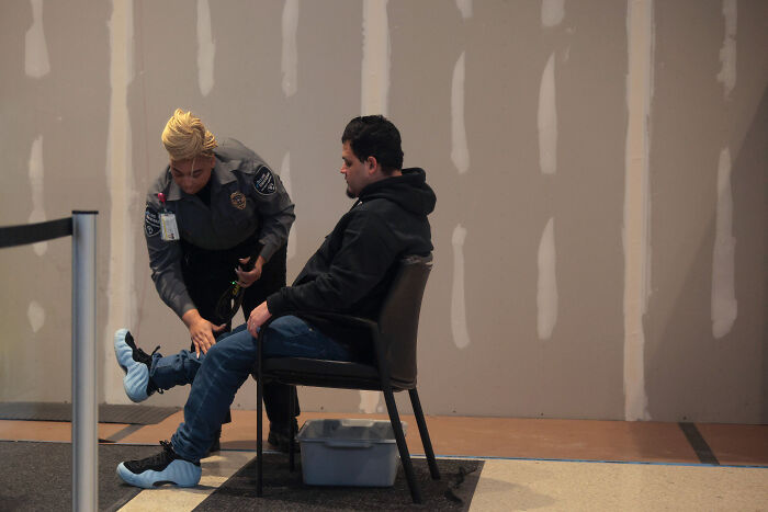 Kilmar Abrego Garcia seated while security officer fits protective shoe covers during public appearance after release Kilmar Abrego Garcia seated while security officer fits protective shoe covers during public appearance after release