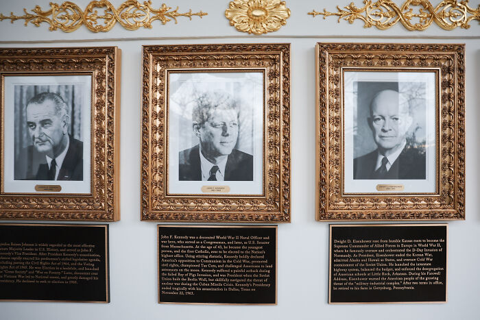 Three framed black and white presidential portraits with plaques beneath, White House plaques added under Biden and Obama portraits.