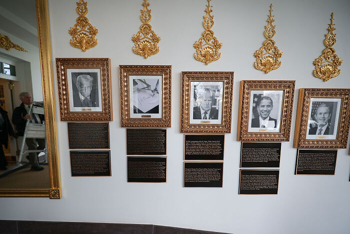 Portraits of Biden and Obama in the White House with newly added plaques referencing Trump as student of history.