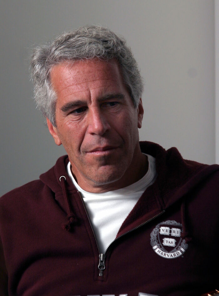 Middle-aged man with gray hair wearing a maroon Harvard hoodie, reflecting on Epstein bank records and island photos news.