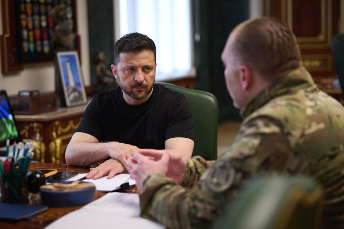 Volodymyr Zelenskyy in a meeting with a military officer discussing Ukraine’s secret deep strike plan amid tensions.