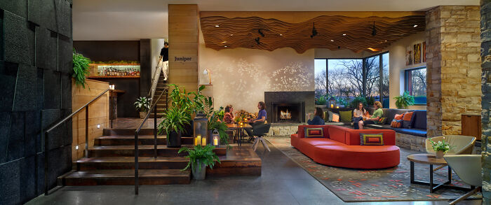 Luxurious hotel lobby with modern design, red seating, indoor plants, and ambient lighting, highlighting luxury hotel spending. Luxurious hotel lobby with modern design, red seating, indoor plants, and ambient lighting, highlighting luxury hotel spending.