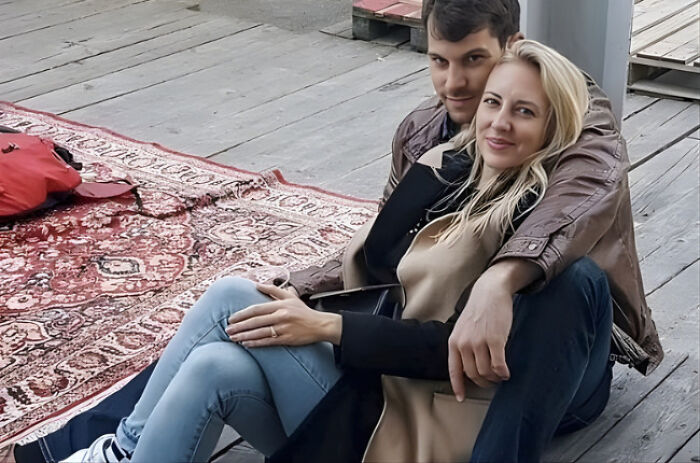 Young couple sitting together on wooden floor with a rug nearby, related to husband charged in disturbing case involving Miss Switzerland finalist wife Young couple sitting together on wooden floor with a rug nearby, related to husband charged in disturbing case involving Miss Switzerland finalist wife