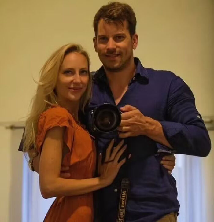 Man holding camera taking selfie with woman in orange dress relating to husband charged in disturbing case keywords Man holding camera taking selfie with woman in orange dress relating to husband charged in disturbing case keywords