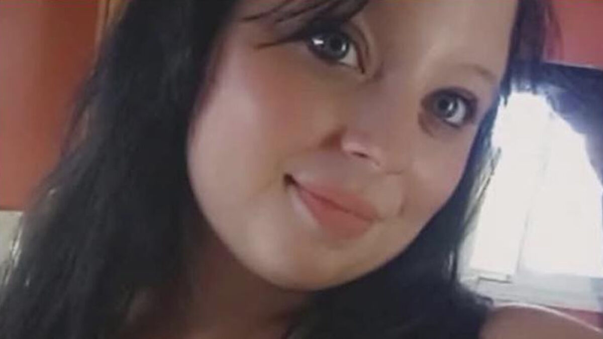 Young woman with dark hair and blue eyes, related to parents accused in case of slain daughter and unborn child separation.