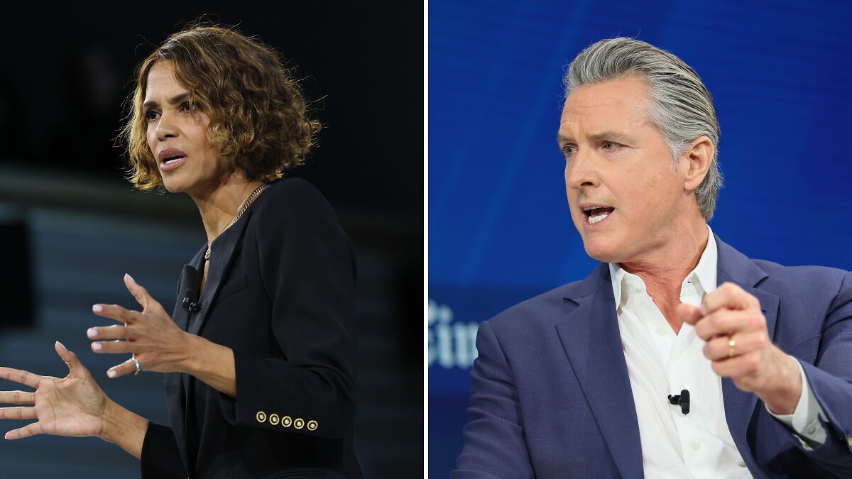 Halle Berry speaking passionately while Gavin Newsom gestures during a political discussion on stage.