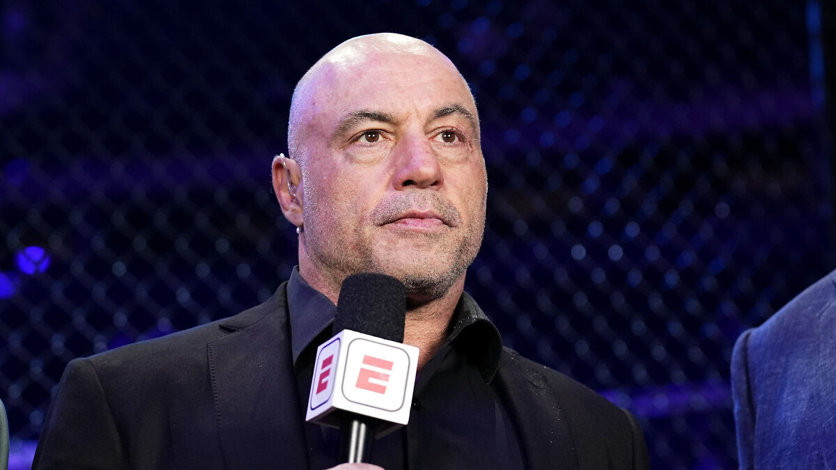 Joe Rogan holding microphone during UFC event, discussing Trumps texting habits and behavior in a sports setting.