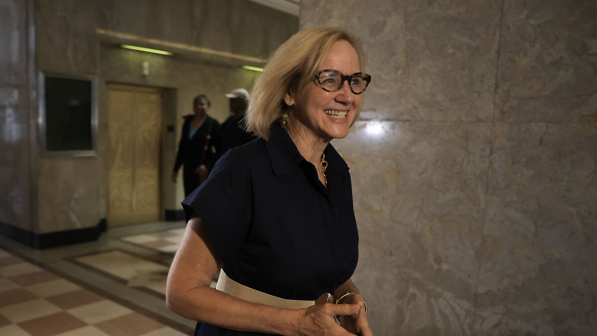 Woman smiling and walking in a building hallway after Miami elects first Democratic mayor in nearly 30 years.