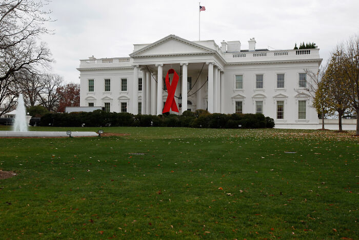 The White House decorated with a large red ribbon symbolizing World AIDS Day commemoration.