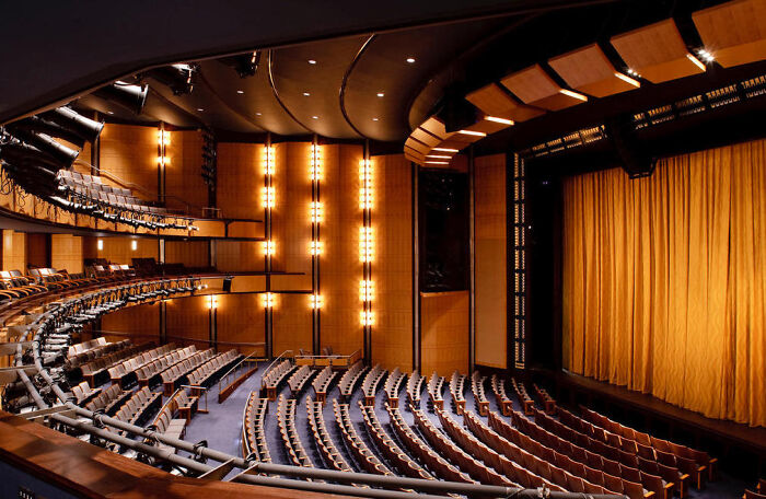 Interior view of Kennedy Center auditorium with empty seats and stage, amid New Year&rsquo;s cancellations and Trump rename backlash.