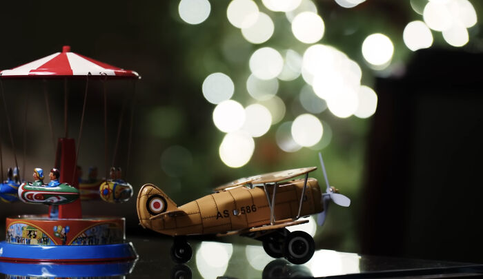 Melania Trump’s 2025 Christmas decorations featuring vintage toy airplane and carousel with festive bokeh lights in the background