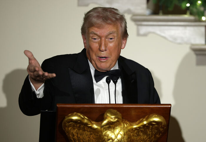 Donald Trump in a black tuxedo speaking at a podium with a golden eagle, sending unnerving signals about future plans. Donald Trump in a black tuxedo speaking at a podium with a golden eagle, sending unnerving signals about future plans.