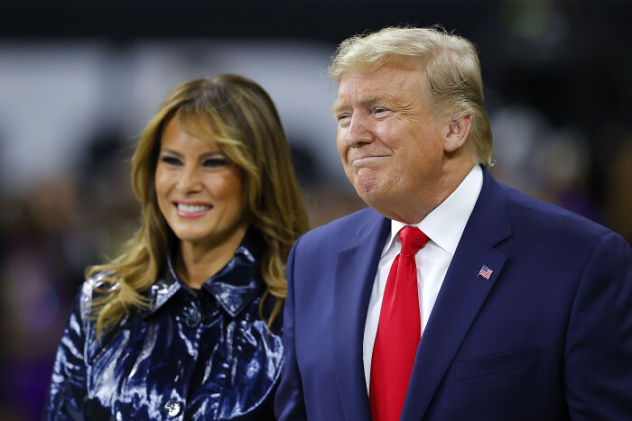 Donald Trump and Melania Trump at a public event with crowd reacting during national anthem at CFP final game.