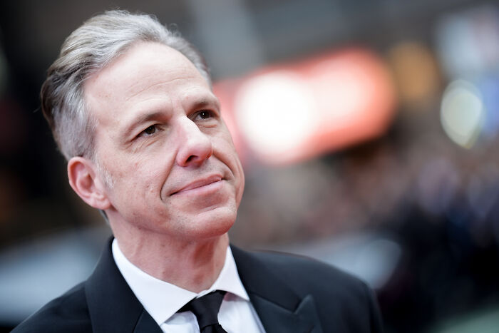 Man in suit and tie at an event, illustrating a reaction related to Kristi Noem and ICE officer controversy.